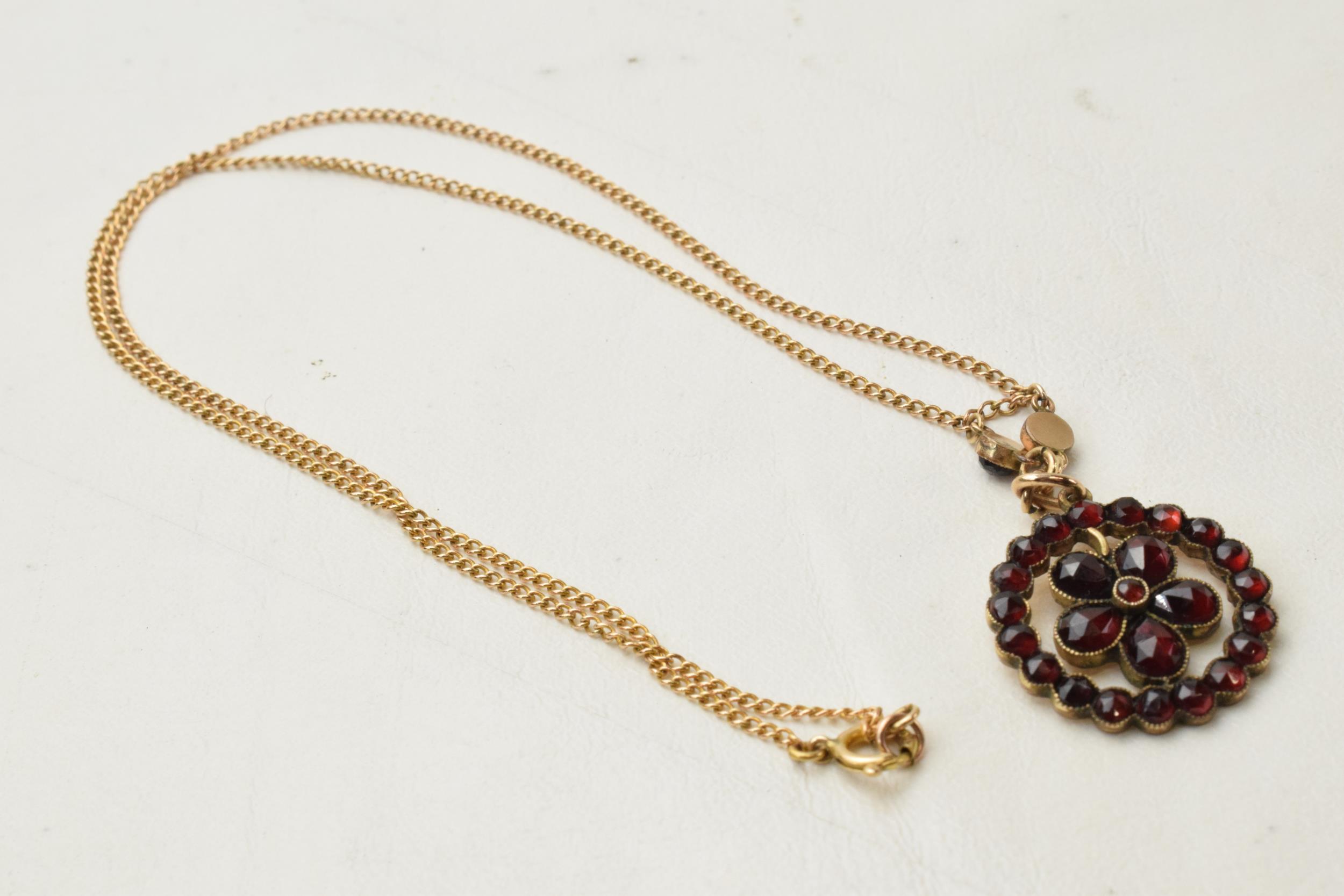 9ct gold chain with gilt metal garnet pendant, total weight 4.3 grams.