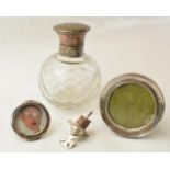 Silver topped cut glass perfume bottle, Birmingham 1919, two small silver photo frames and a