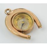 Gold plated horseshoe watch fob with agate face and compass, 3.5cm long.