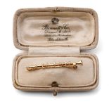 9ct gold diamond set bar brooch in the form of a clarinet, 2.5 grams, 4.5cm wide.
