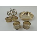 A collection of silver items to include a 5 bar toast rack, 2 pairs of napkin rings and an