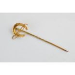 9ct gold stick pin in the form of a riding crop and horseshoe, stamped 9ct, 5cm tall, base metal