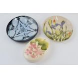A Moorcroft pink floral oval trinket box with 2 Cobridge Stoneware pin dishes, 15cm diameter (3). In