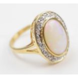 14ct gold ring set with a large opal stone surrounded by diamonds, stamped 585, 5.3 grams, size O/P.