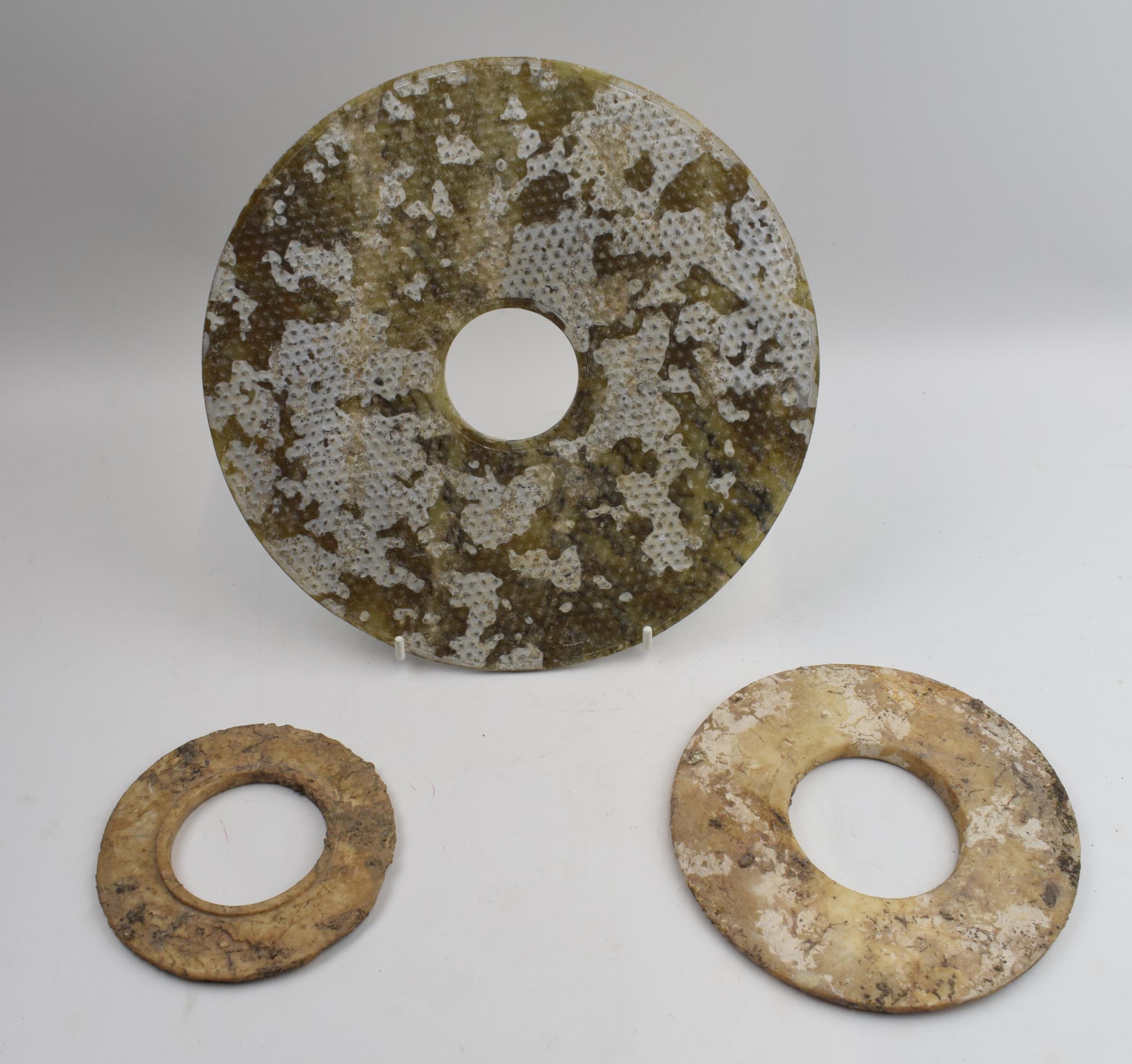 Three Chinese Bi discs, jade or similar of varying sizes.largest 24cm diameter.