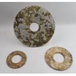 Three Chinese Bi discs, jade or similar of varying sizes.largest 24cm diameter.