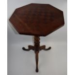 Edwardian inlaid games table with three-legged base, 47cm diameter, 71cm tall. Old worm noted,