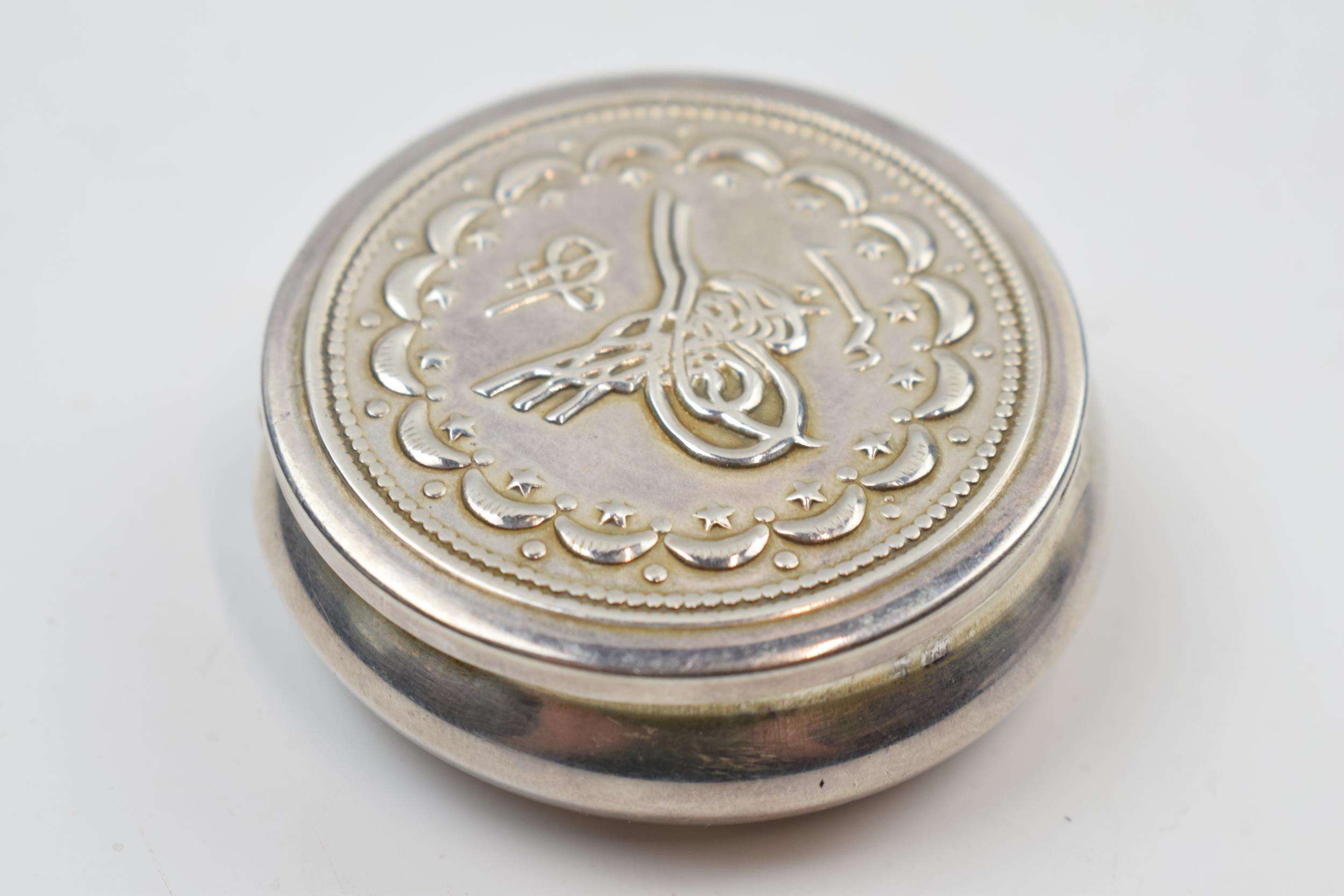 Silver .900 modern pill box with repousse decoration, 28.8 grams.