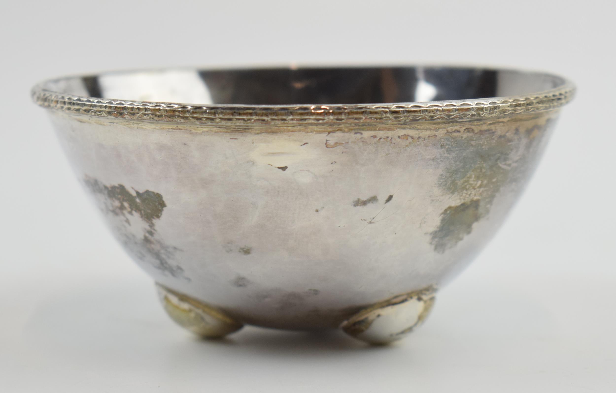 Unusual silver bowl with hammered design raised on 3 feet, 82.6 grams, 8cm diameter, London 1961,