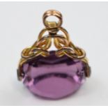 Gilt metal fob with amethyst style stone.