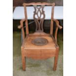 Pine commode chair with ornate back and ceramic liner, 103cm tall. Displays well, on casters, has