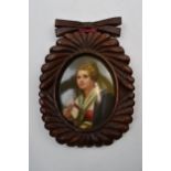 Oval painted ceramic portrait of a girl holding a flower in wooden frame, plaque 8cm long.