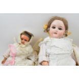 A pair of dolls to include an early to mid 20th century 'Specied' Made in Germany bisque head doll