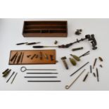 A collection of vintage gun cleaning and cartridge making accessories to include rods, brushes and