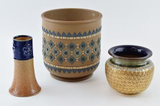 A trio of Doulton Stoneware to include a hunting horn form vase with floral design, a gilt vase