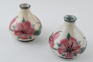A pair of Cobridge Stoneware pottery vases with pink floral design, 10cm tall (2). In good condition