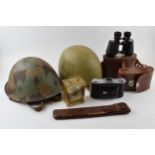 A mixed collection of items to include military helmet, vintage motorcycle helmet, camera and