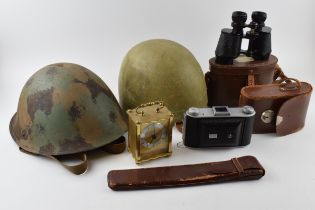 A mixed collection of items to include military helmet, vintage motorcycle helmet, camera and