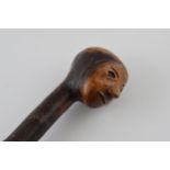 Early 20th century folk art walking stick with carved figural head, 89cm tall.