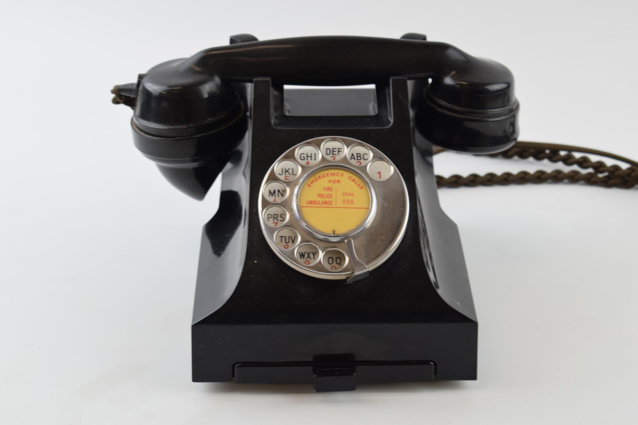 Vintage bakelite telephone and base, with wire.