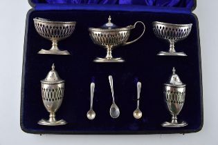 Cased hallmarked silver 5 piece cruet set with pierced decoration, with assosciated silver spoons,