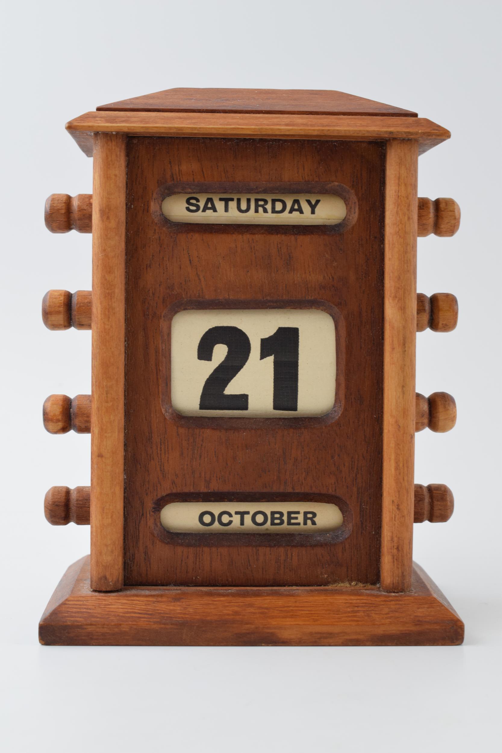 Vintage style perpetual calendar in wooden case with scroll like action, 17cm tall.