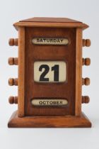 Vintage style perpetual calendar in wooden case with scroll like action, 17cm tall.