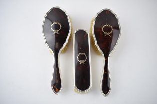 A trio of hallmarked silver brushes with tortoiseshell inserts with inlaid decoration (3). Hallmarks