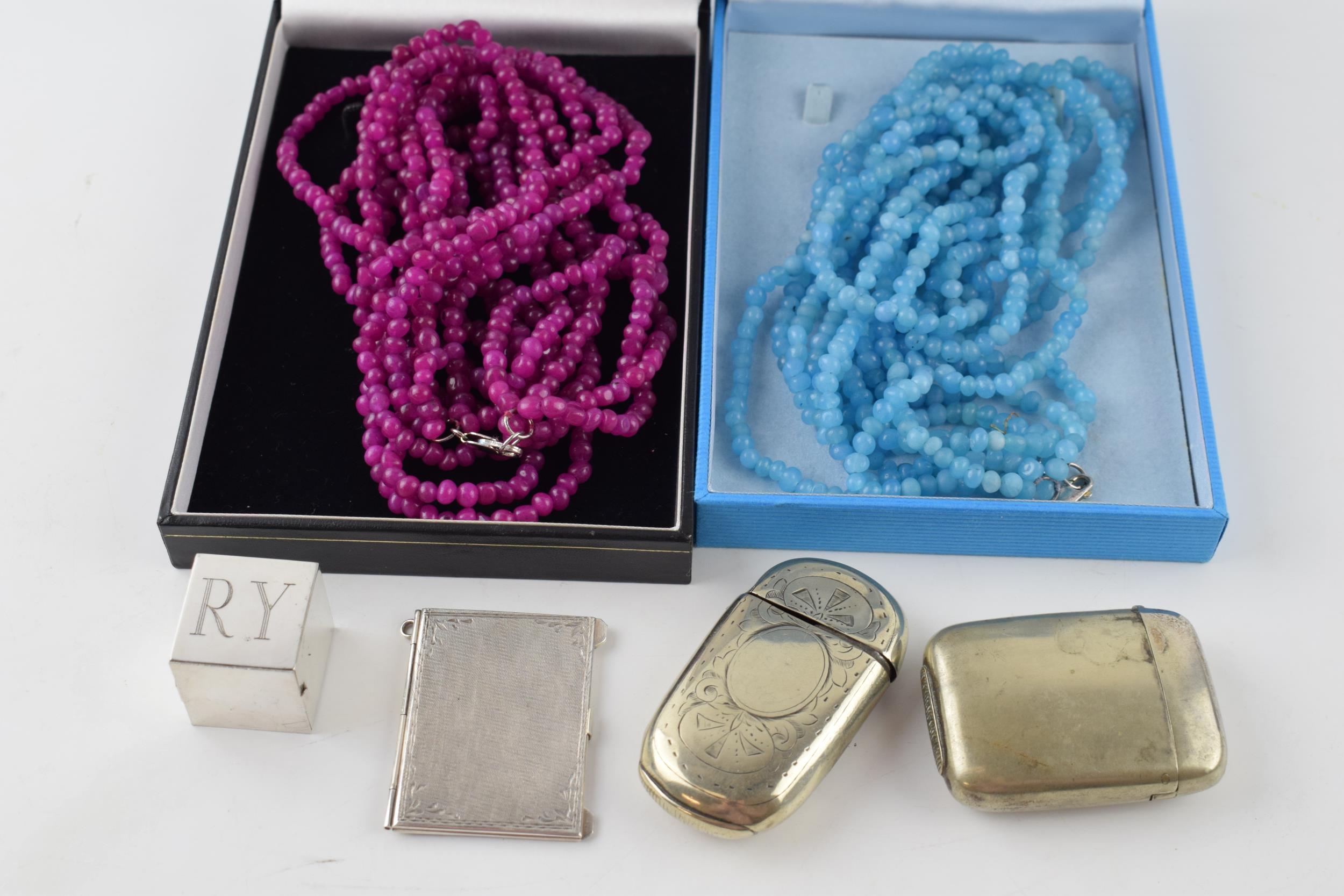 A collection of items to include a silver 800 stamp case, plated vesta cases, a white metal