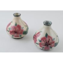 A pair of Cobridge Stoneware pottery vases with pink floral design, 10cm tall (2). In good condition