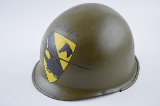 An American military helmet with 'Vietnam' and helicopter crest to front.