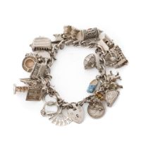 Silver charm bracelet with various charms to include a house, an anvil, a toaster, a book and