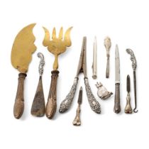 A collection of silver items to include silver handled glove stretchers, a cat baby rattle, shoe