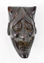 A hardwood hand carved Netsuke in the form of a horned demonic /devil figure. Buddhist or Daoist