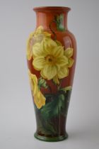 Doulton Lambeth Faience high-shouldered vase decorated with Daffodils on red / deep orange
