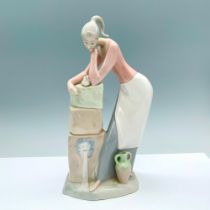 Spanish Porcelain Figurine of a Woman Resting by a Fountain