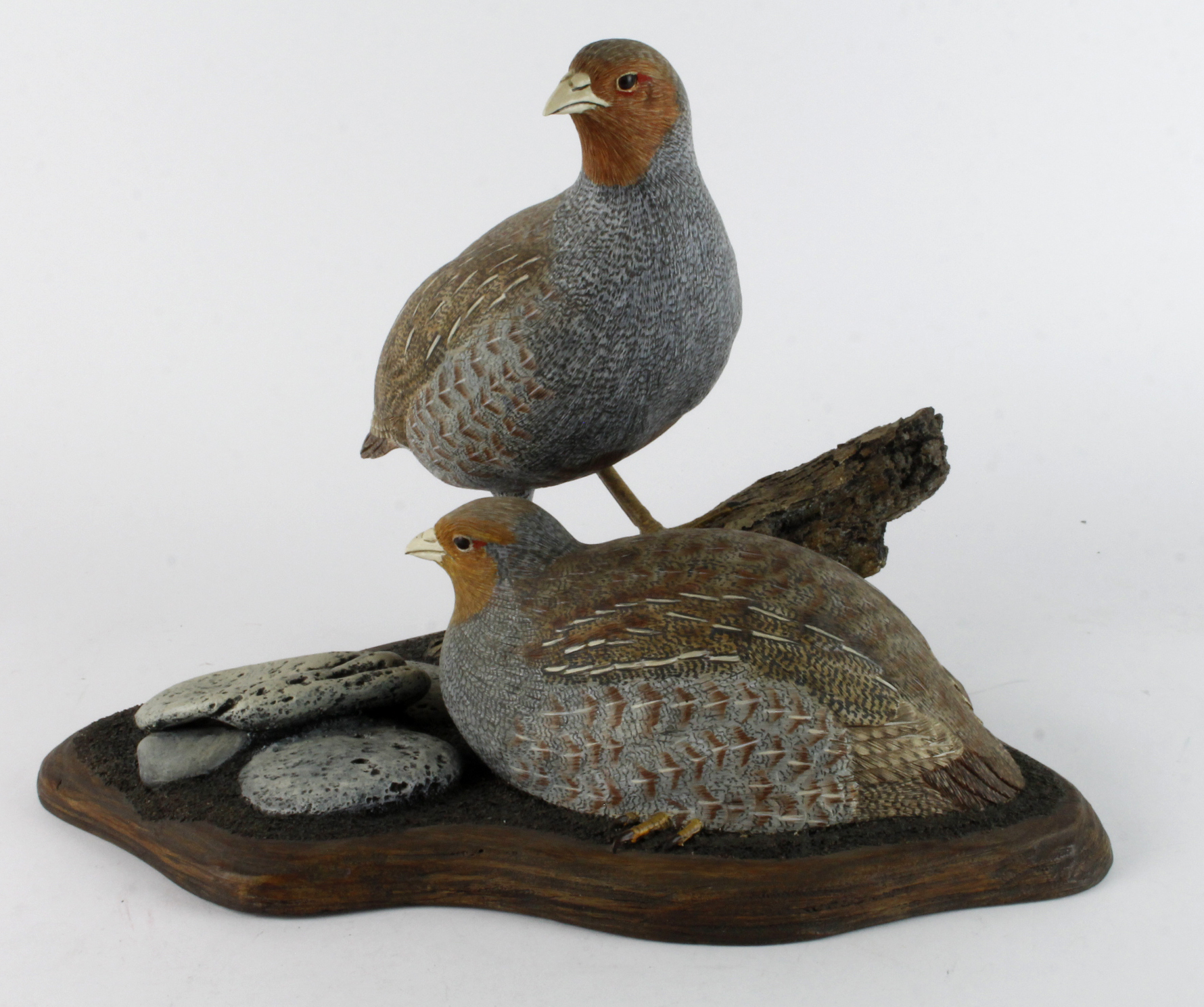 Mike Wood. A carved wood sculpture by Mike wood, titled to base 'Grey Partridge', depicting a pair