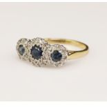 Yellow gold (tests 18ct) sapphire and diamond trilogy cluster ring, three graduating round sapphires
