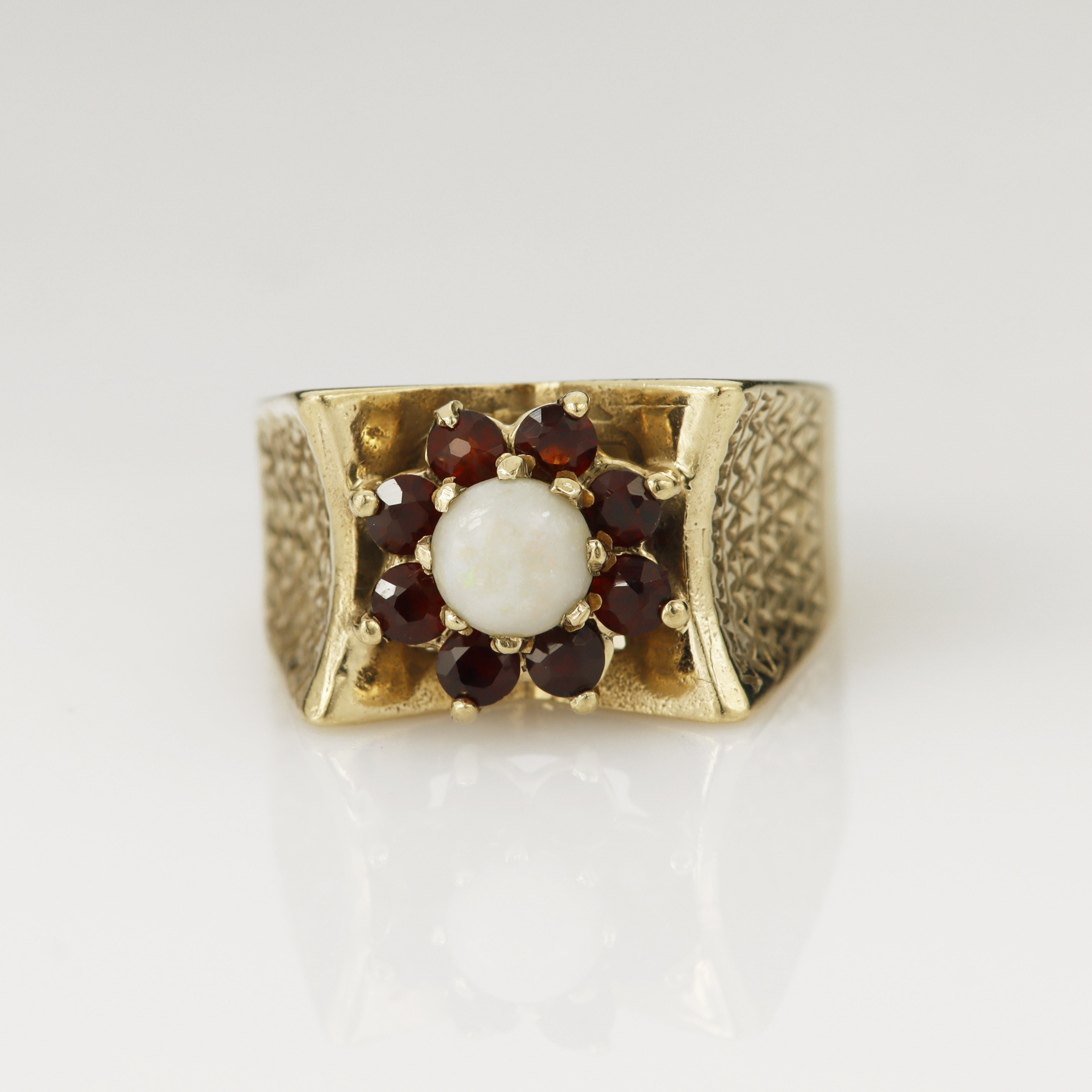Yellow gold (tests 9ct) garnet and opal cluster ring, round cabochon opal measures 5mm, surrounded