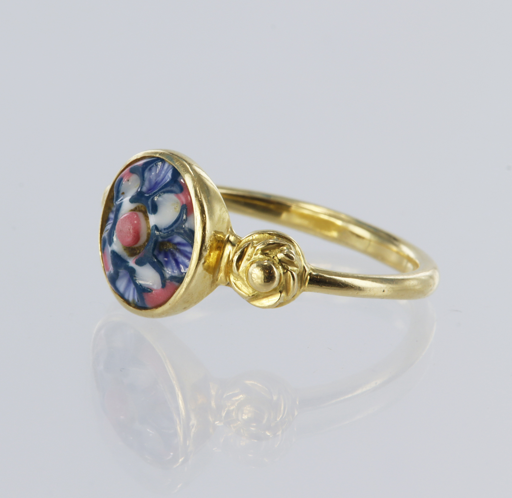 Yellow metal (tests 18ct) ring set with a round ceramic blue/pink stone measuring approx. 10mm