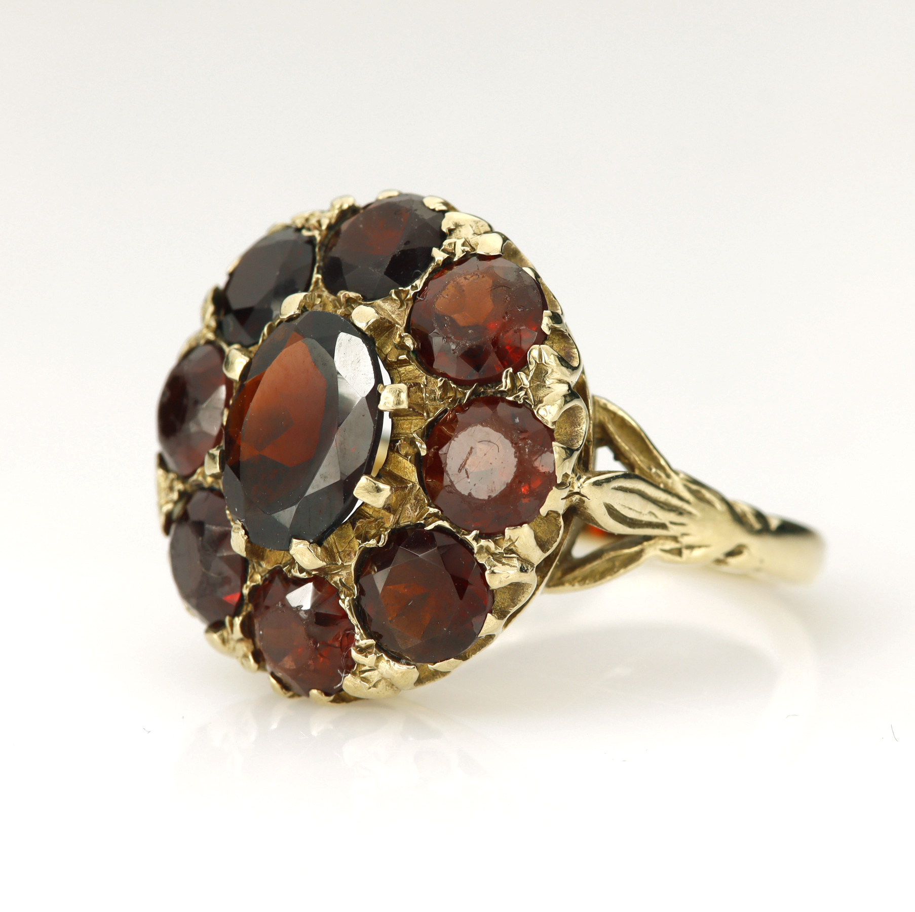 9ct yellow gold garnet cluster dress ring, principle oval cut measures 8.9mm x 7mm, surrounded by