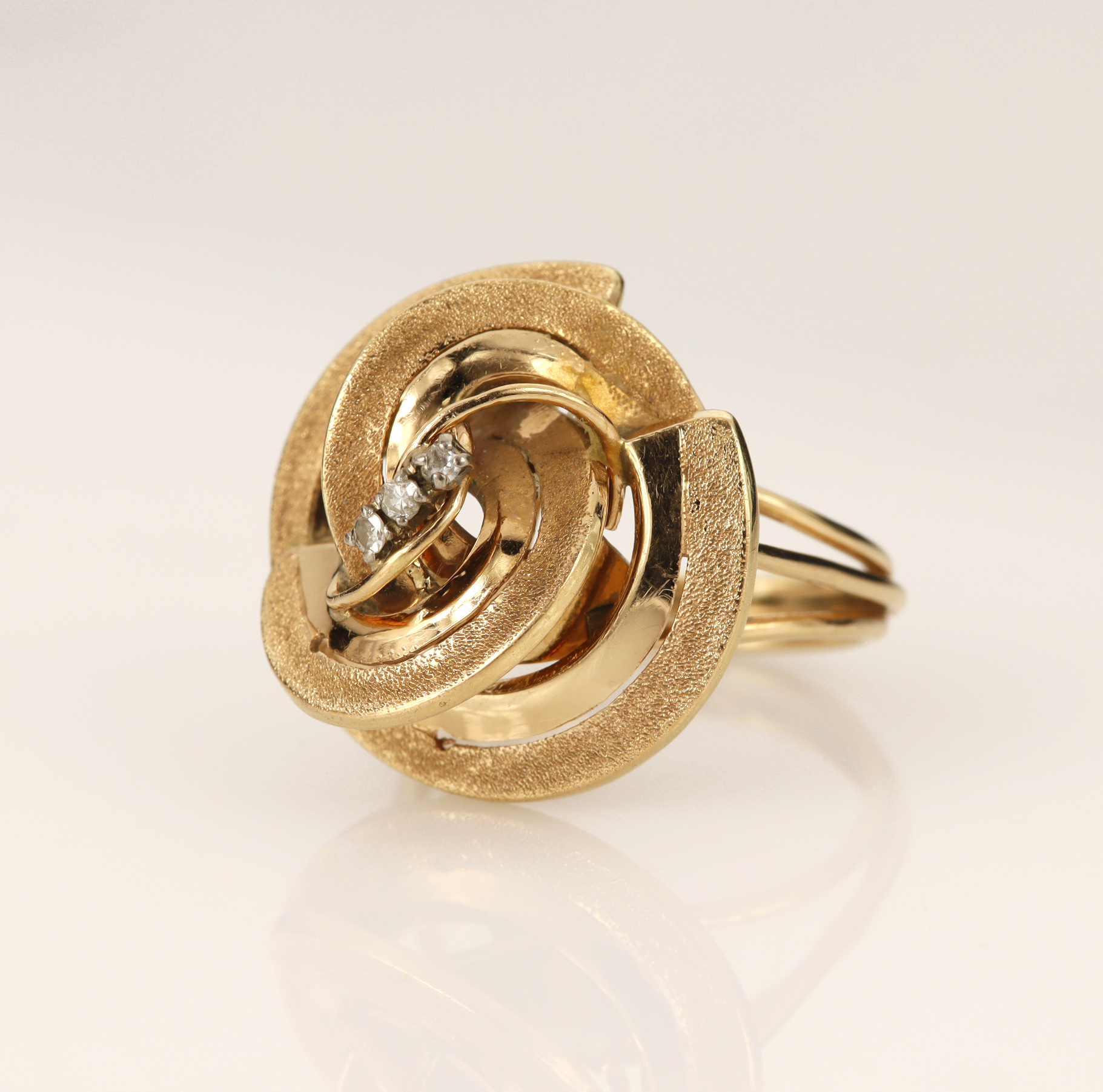 Rose gold (tests 18ct) contemporary spiral ring, set with three single cut diamonds total weight