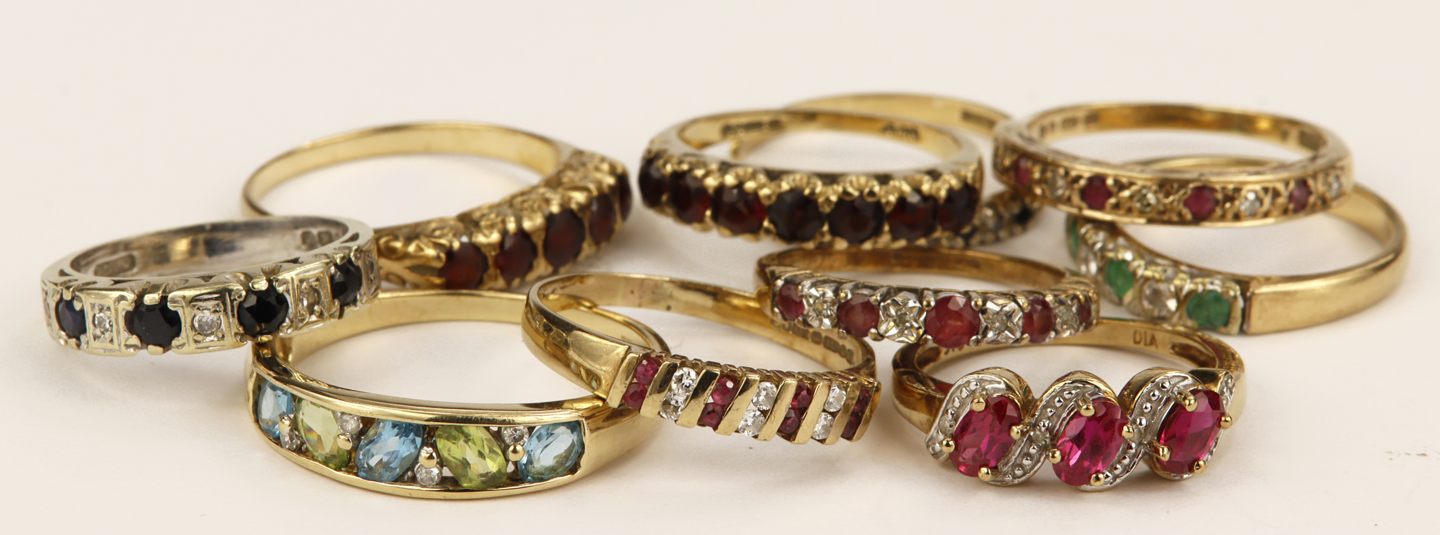 Ten 9ct gold gemset eternity rings, stones include diamond, ruby, sapphire, emerald, synthetic ruby,