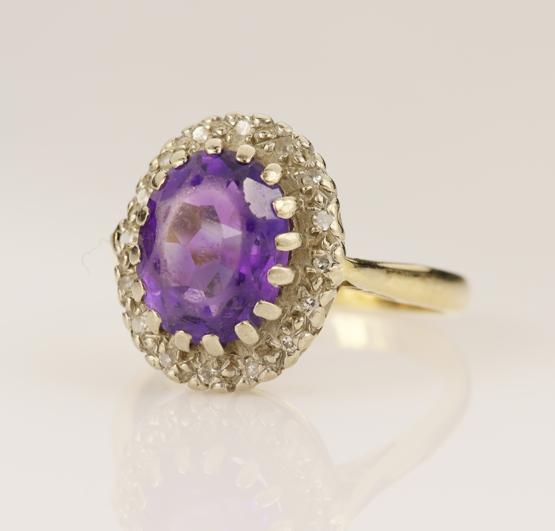 Yellow gold (tests 18ct) amethyst and diamond cluster ring, oval mixed cut amethyst measures 9.7mm x