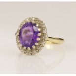 Yellow gold (tests 18ct) amethyst and diamond cluster ring, oval mixed cut amethyst measures 9.7mm x