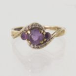 9ct yellow gold graduated amethyst three stone ring with ten round diamonds in a crossover style,
