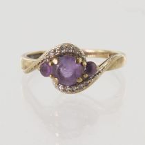 9ct yellow gold graduated amethyst three stone ring with ten round diamonds in a crossover style,
