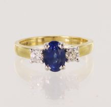 18ct yellow gold diamond and sapphire trilogy ring, oval mid-blue sapphire measures 7.3mm x 5.1mm