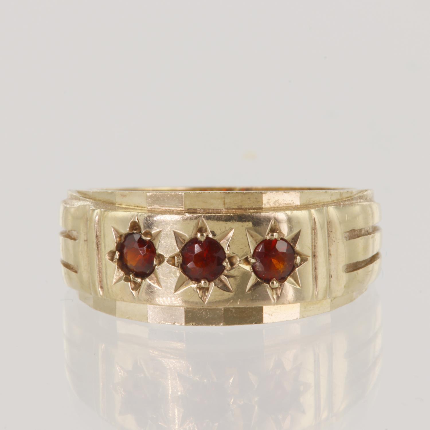 9ct yellow gold garnet set gypsy ring, three round garnets in a star setting, head measures 9.5mm,