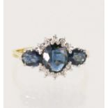18ct yellow gold diamond and teal sapphire trilogy cluster ring, principle oval sapphire measures